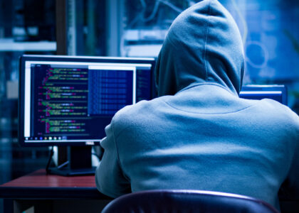 a person in a hoodie looking at a computer screen